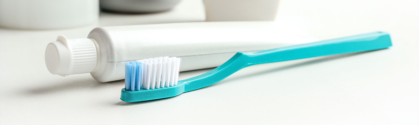 The image shows two toothbrushes with blue bristles placed next to each other on a surface.