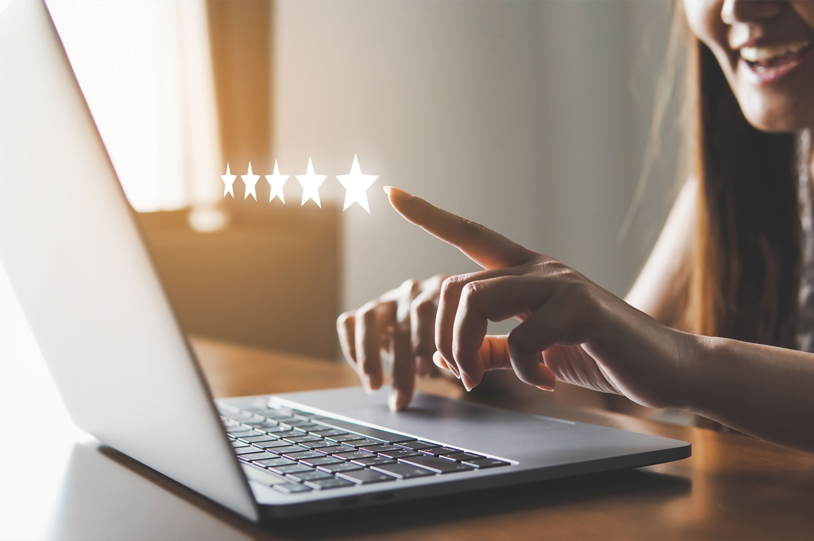 A person s hand pointing at a laptop screen with a star rating graphic, suggesting positive feedback or approval.