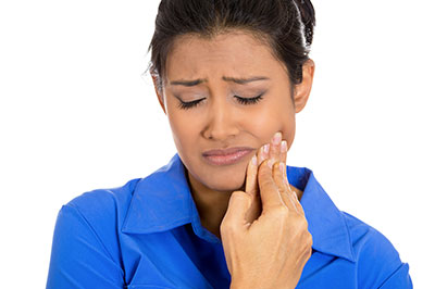 The image shows a woman with her eyes closed, holding her hand up to her face, possibly in a moment of surprise or concern.